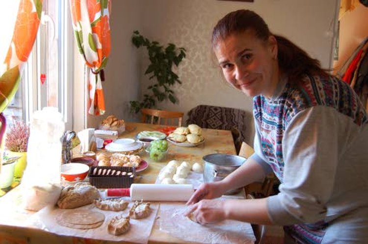 Kalevalassa asuva Natalia Nikutjeva leipoo suussa sulavia runsastäytteisiä karjalanpiirakoita. Taustalla keko vehnäjauhopohjaisia perunapiirakoita.
