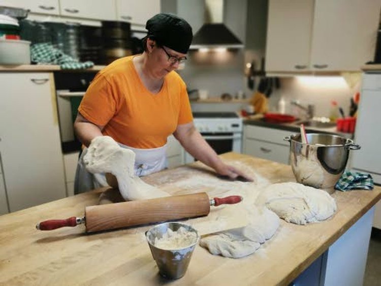 – Käsin alustettu pullataikina on huomattavasti tiiviimpi kuin koneellisesti alustettu. Käsin alustetusta taikinasta leivottu pulla tuntuu kädessä selvästi painavammalta, Sanna Herrala kertoilee leipomisen lomassa.